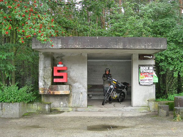 Met motor en al schuilen in een bushokje