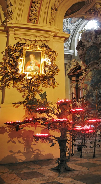 Metalen boom met kaarsjes voor schilderij van Maria