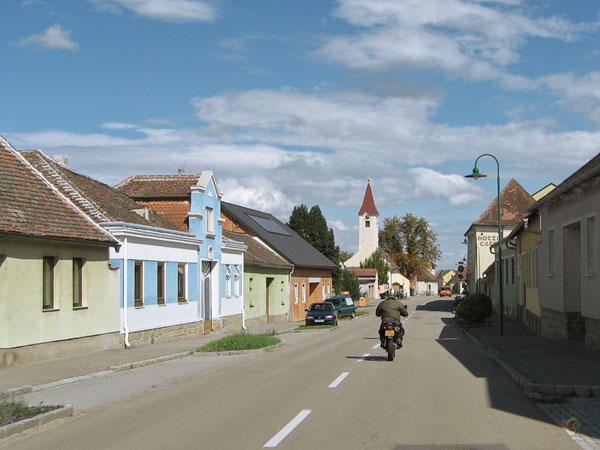 Straat met lage huizen en kerkje