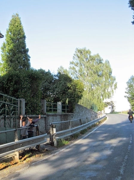 Zwaaiende jongetjes aan de kant van de weg