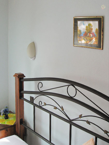 Bed met schilderijtje er boven