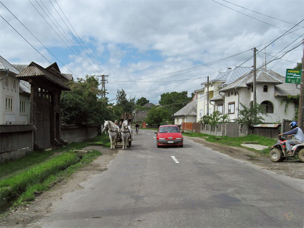 Quad, auto, paard en wagen fietser, huizen