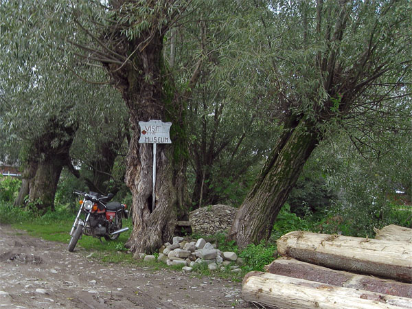 Bord met Visit Museum, geplant in Wilg, met ernaast een Moto Morini