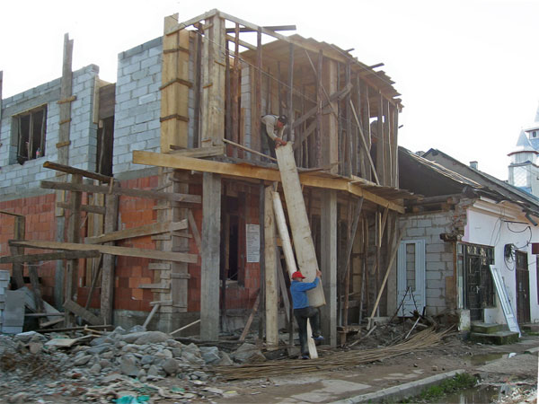 Aan het werk met houten balken bij een huis in aanbouw