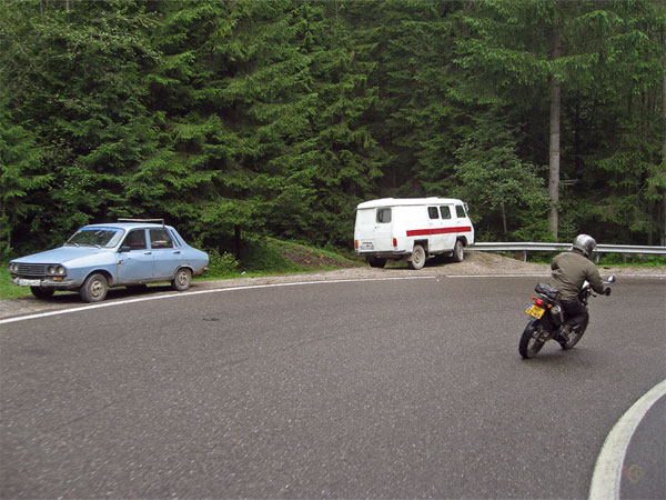 Twee geparkeerde auto's, bocht, bos