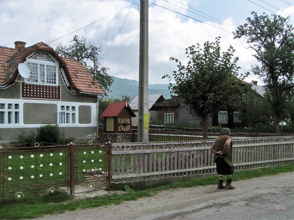 Huis, hek en oude vrouw