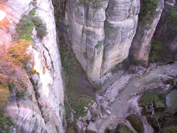 Loodrechte kloof met water onderin, van boven gezien