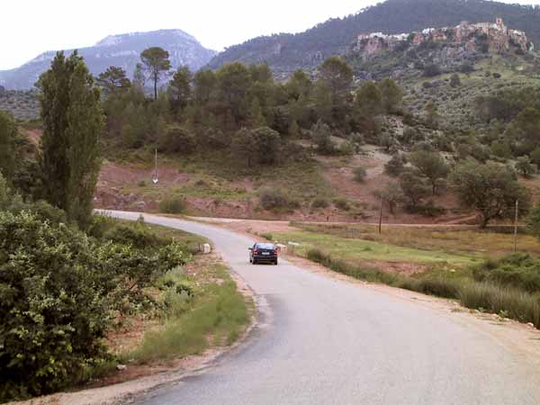 Auto. Wit dorpje op tafelberg daarachter