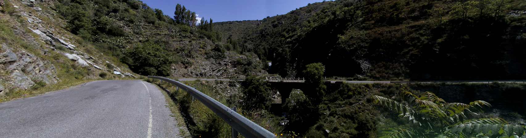 Bocht met brug over riviertje, rotsen