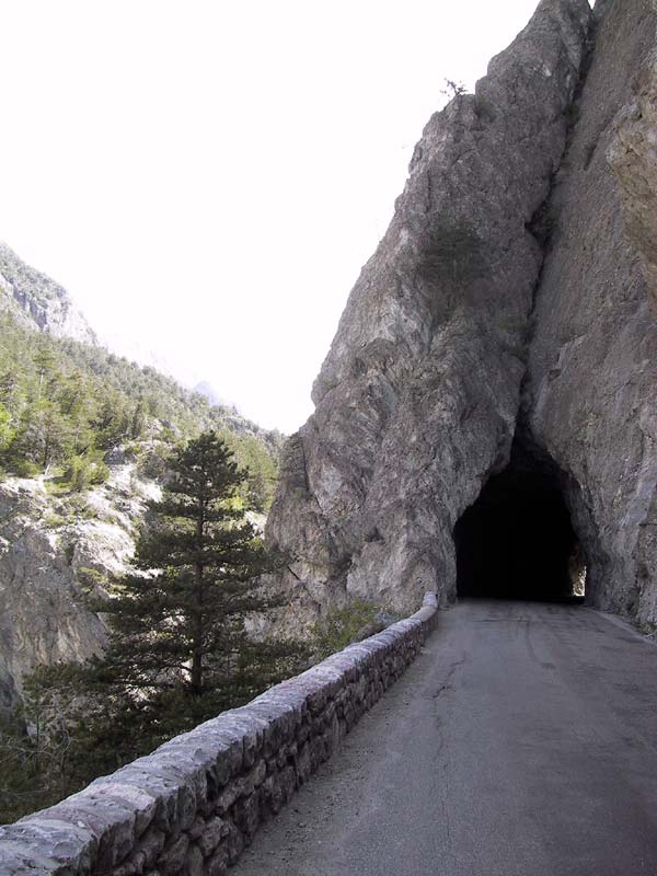 Weg door donker tunneltje, door rots heen