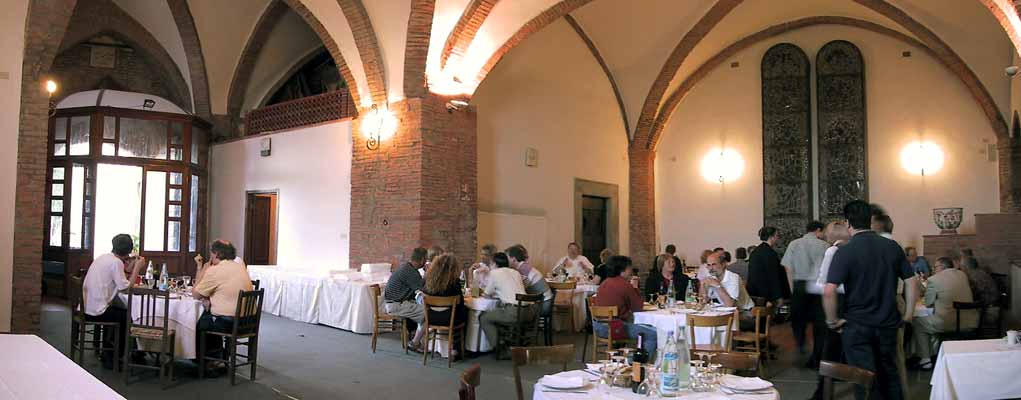 Eetzaal met bogen in het plafond en twee hoge gebrandschilderde ramen