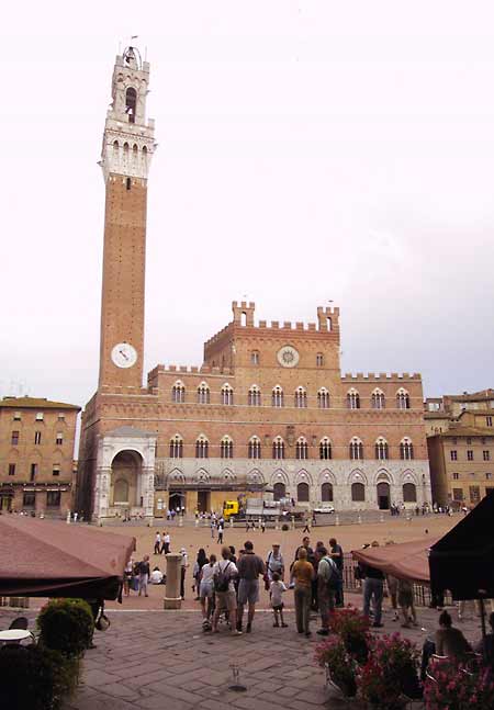 Brick building, castle-like, withe high, slender tower, at a square